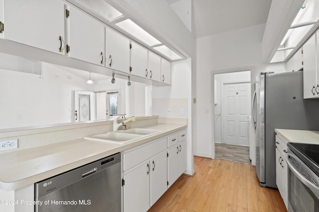 kitchen featuring white cabinetry, light wood-type flooring, stainless steel appliances, and sink