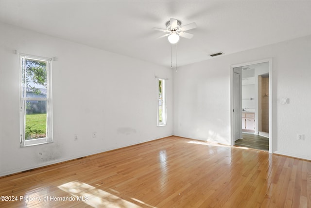 empty room with hardwood / wood-style flooring and a healthy amount of sunlight