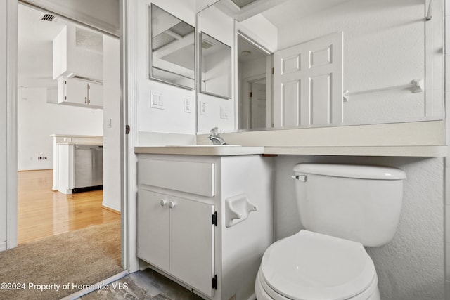 bathroom with vanity, toilet, and hardwood / wood-style floors