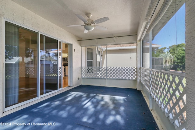 unfurnished sunroom featuring ceiling fan