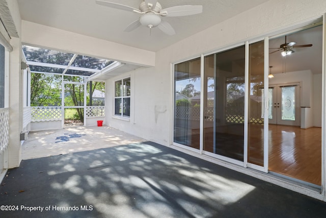 unfurnished sunroom featuring ceiling fan