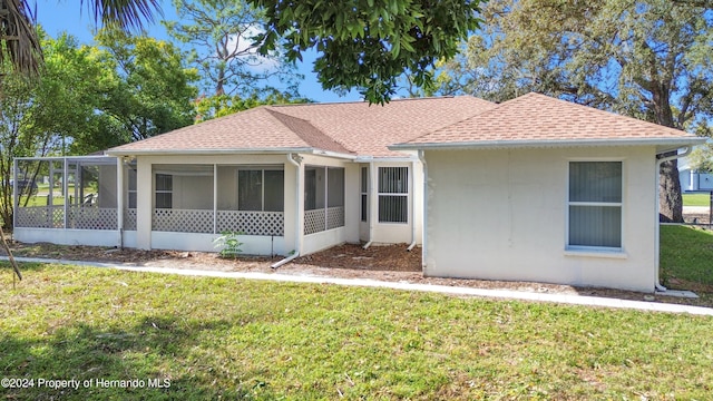 view of front of home featuring a sunroom and a front lawn