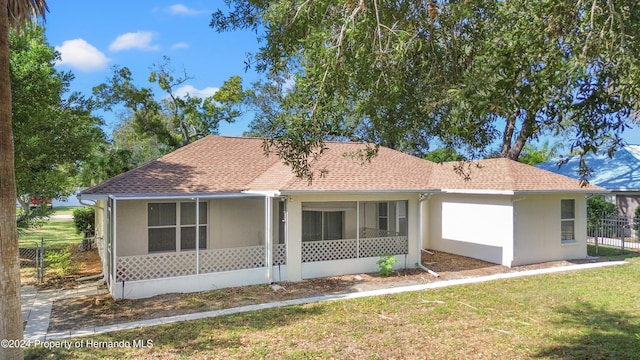 view of front of home with a front yard and a sunroom