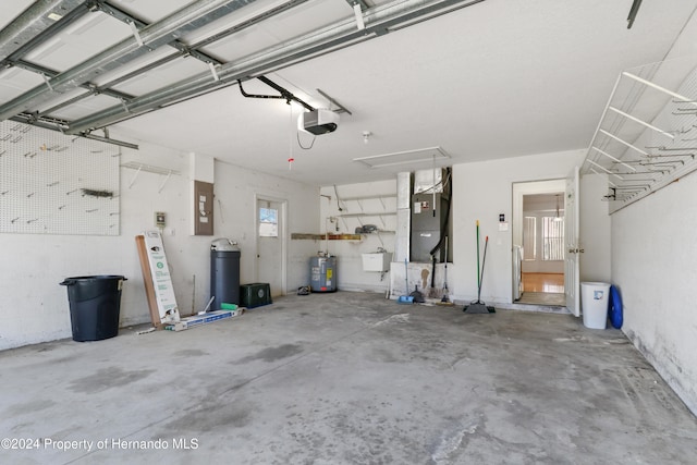 garage featuring electric panel, heating unit, water heater, sink, and a garage door opener