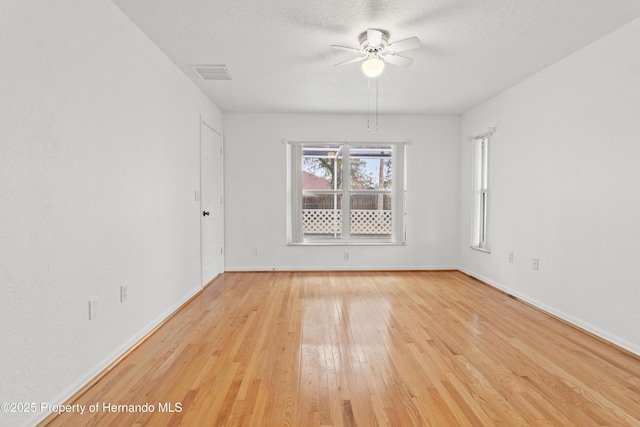 spare room featuring ceiling fan, light hardwood / wood-style floors, and a textured ceiling