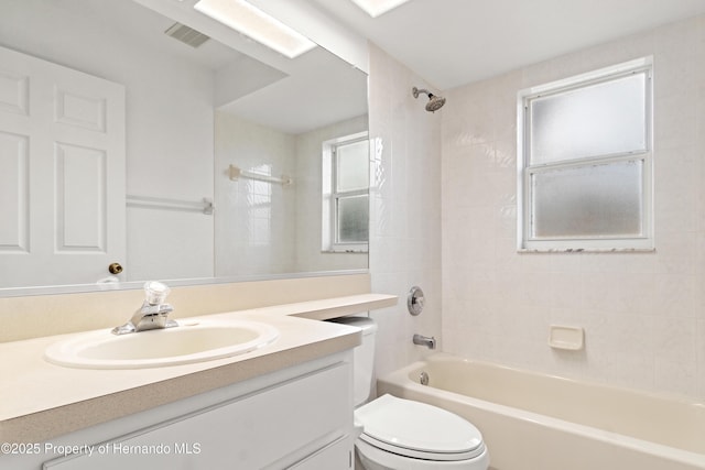 full bathroom featuring tiled shower / bath combo, vanity, and toilet