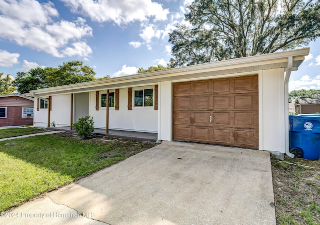 view of front of home featuring a garage, a front yard, and covered porch