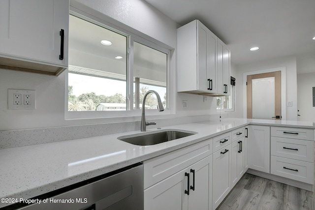 kitchen featuring light hardwood / wood-style flooring, sink, light stone counters, and white cabinets