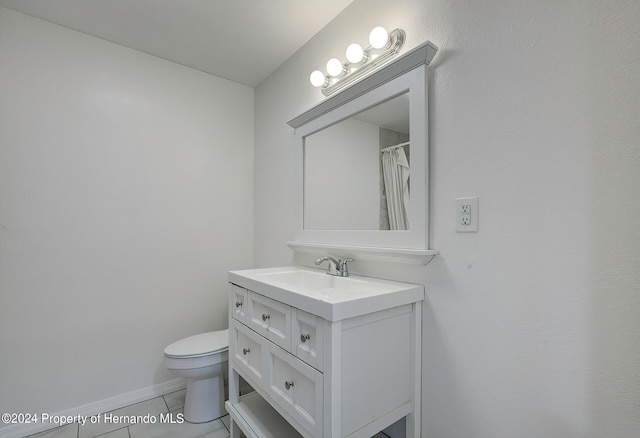 bathroom with tile patterned flooring, vanity, and toilet