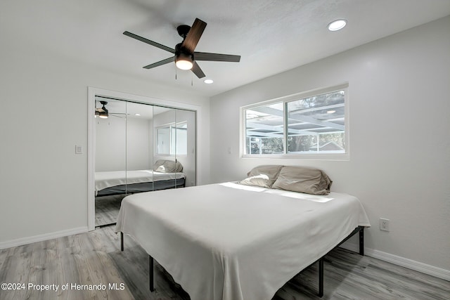 bedroom with ceiling fan, a closet, and light wood-type flooring