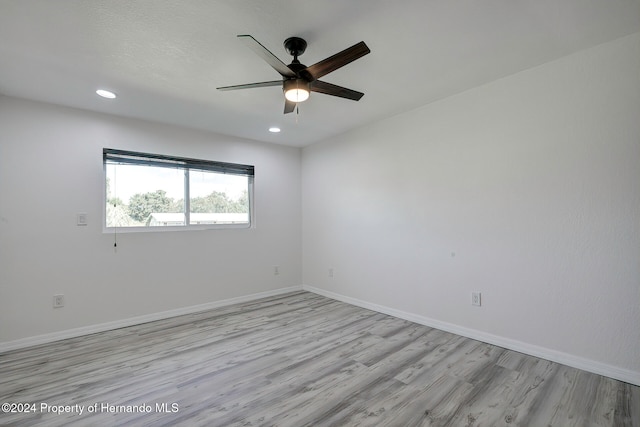 spare room with ceiling fan and light wood-type flooring