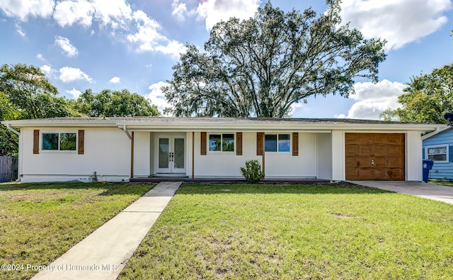 single story home with a garage, french doors, and a front yard