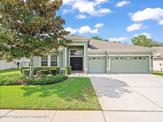 view of front of house with a front yard and a garage