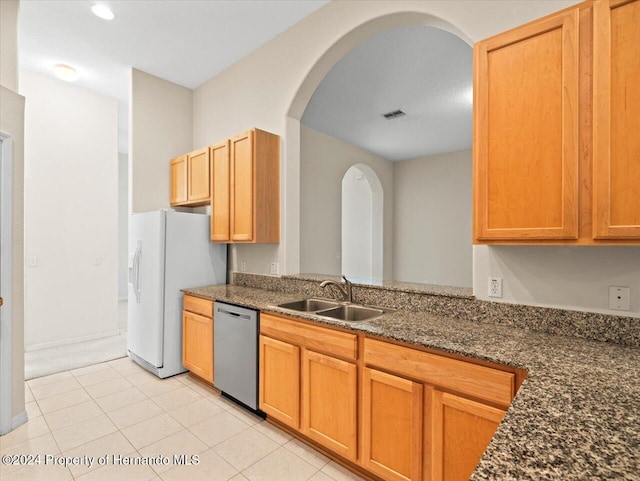 4264 Braemere Dr, Brooksville, FL 34609 - kitchen with sink, white refrigerator with ice dispenser, stainless steel dishwasher, light tile patterned flooring, and dark stone countertops
