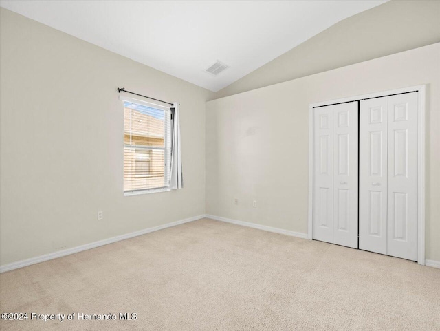 4264 Braemere Dr, Brooksville, FL 34609 - unfurnished bedroom with a closet, vaulted ceiling, and light carpet