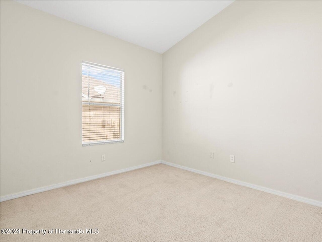 4264 Braemere Dr, Brooksville, FL 34609 - empty room with vaulted ceiling and light colored carpet
