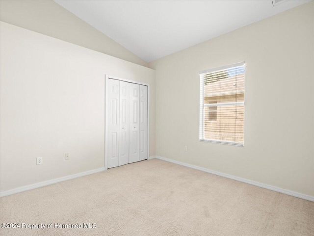 4264 Braemere Dr, Brooksville, FL 34609 - unfurnished bedroom featuring a closet, lofted ceiling, and light colored carpet
