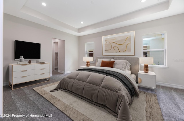 bedroom featuring a tray ceiling and dark carpet