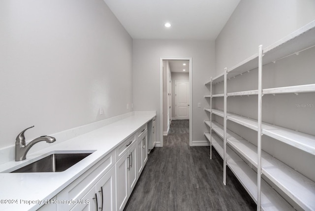 interior space with dark hardwood / wood-style flooring, sink, and white cabinets