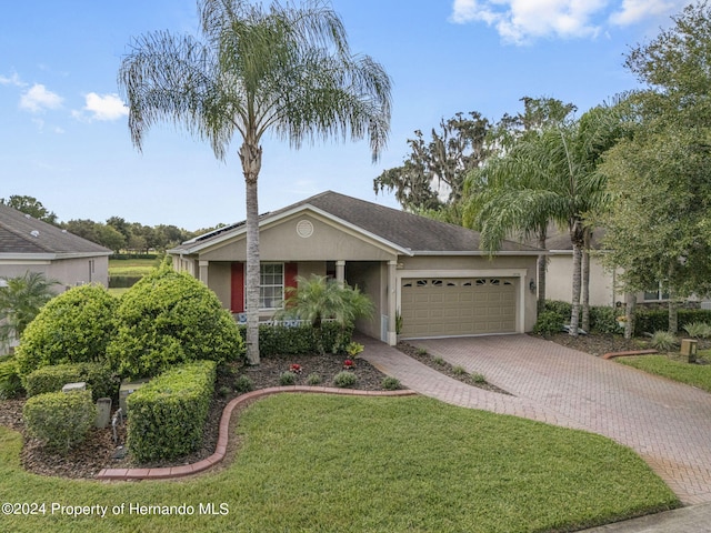 ranch-style house featuring a garage and a front yard