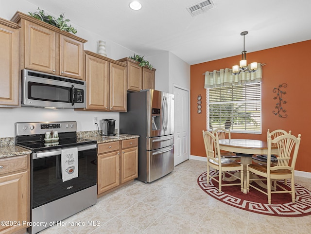 kitchen featuring stainless steel appliances, light tile patterned floors, light stone counters, and an inviting chandelier