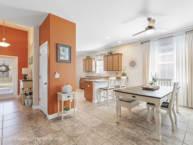 dining area with ceiling fan and sink