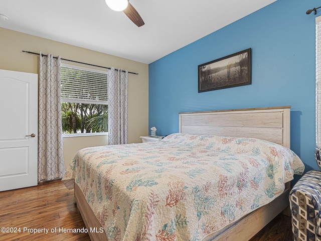 bedroom with dark hardwood / wood-style flooring and ceiling fan