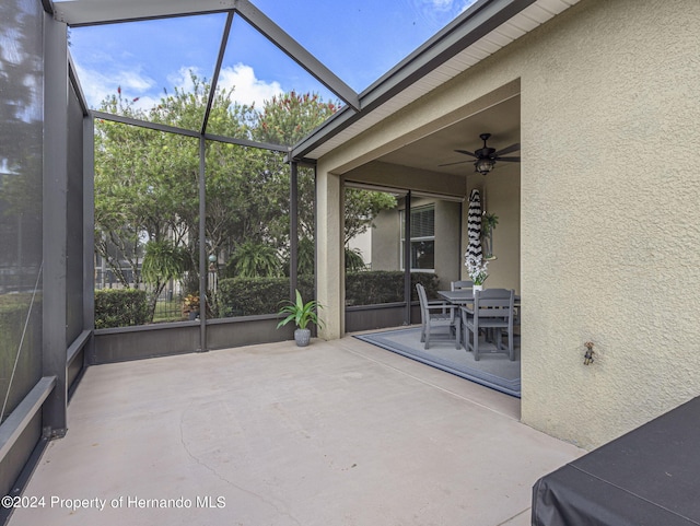 unfurnished sunroom with ceiling fan