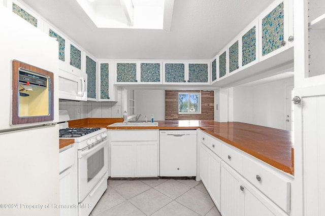 kitchen with white cabinets, kitchen peninsula, sink, backsplash, and white appliances