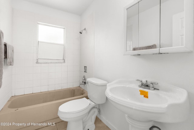 full bathroom with toilet, tile patterned flooring, tiled shower / bath combo, and sink