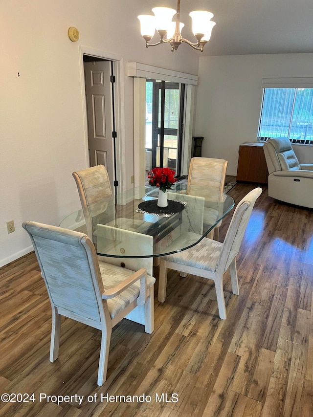 dining room with dark hardwood / wood-style flooring and an inviting chandelier