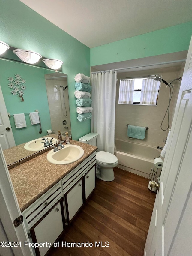 full bathroom with vanity, wood-type flooring, toilet, and shower / tub combo with curtain