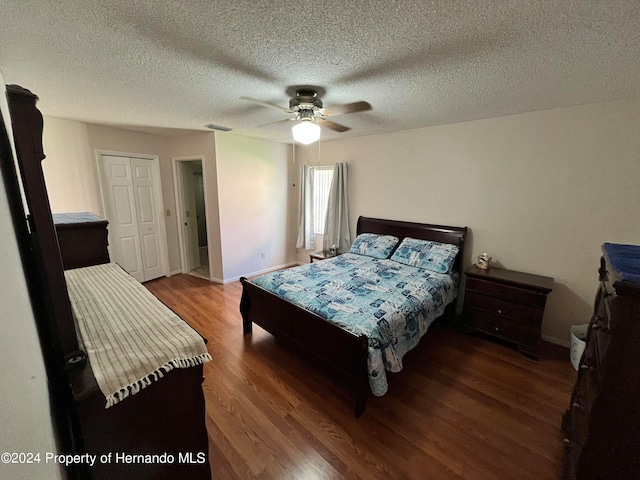 bedroom with a textured ceiling, dark hardwood / wood-style floors, and ceiling fan