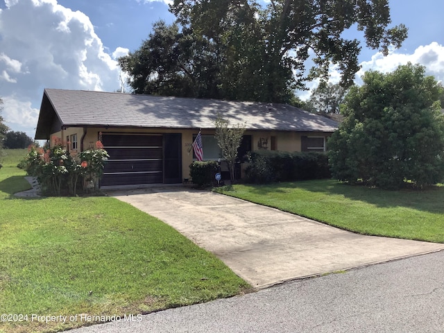 single story home with a garage and a front lawn