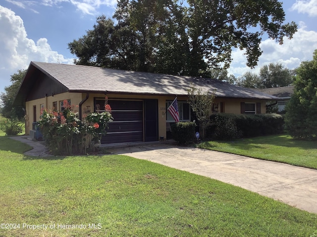 single story home with central air condition unit, a garage, and a front yard