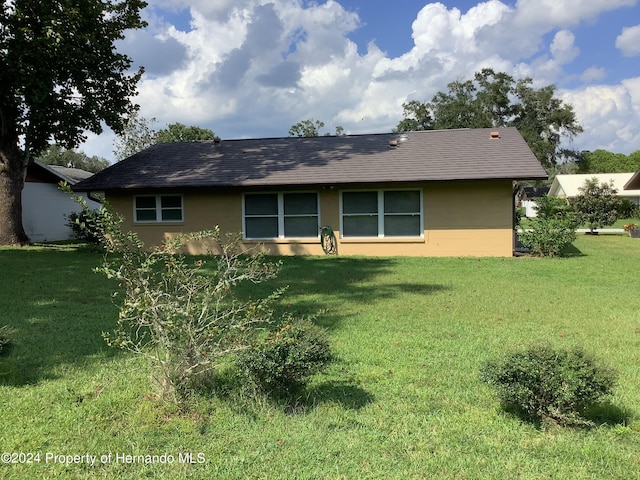 back of property featuring a lawn