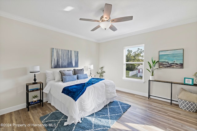 bedroom with ornamental molding, hardwood / wood-style floors, and ceiling fan