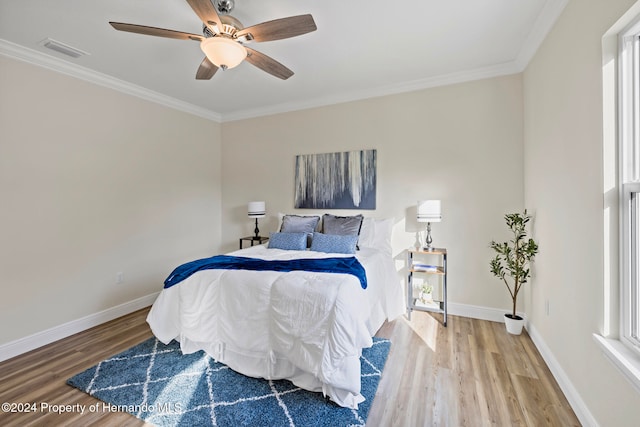 bedroom featuring hardwood / wood-style floors, ceiling fan, and ornamental molding