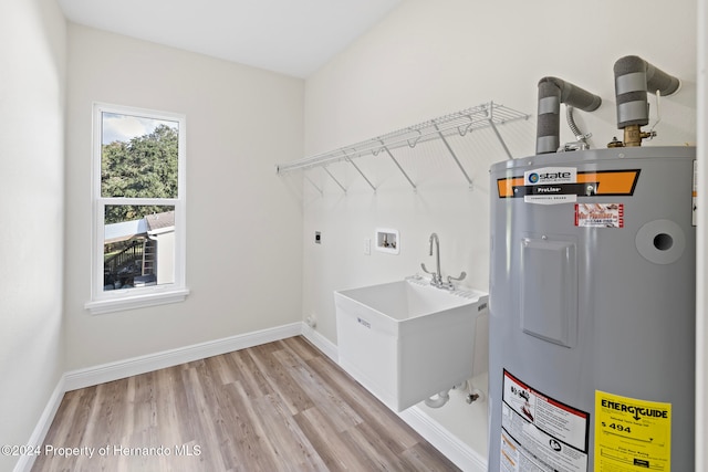 laundry area with hookup for an electric dryer, washer hookup, sink, light hardwood / wood-style floors, and electric water heater