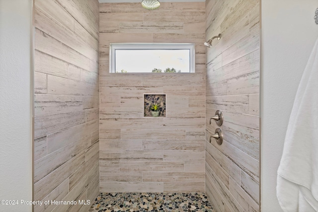 bathroom with wooden walls and a tile shower