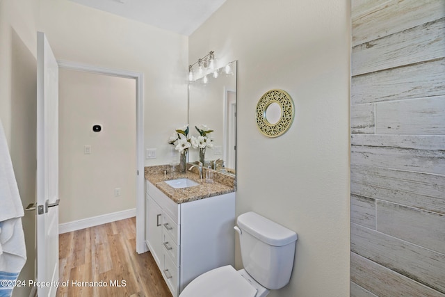 bathroom featuring vanity, toilet, and wood-type flooring