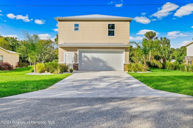 view of property featuring a garage and a front yard