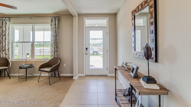 foyer entrance with light tile patterned flooring, plenty of natural light, and beam ceiling