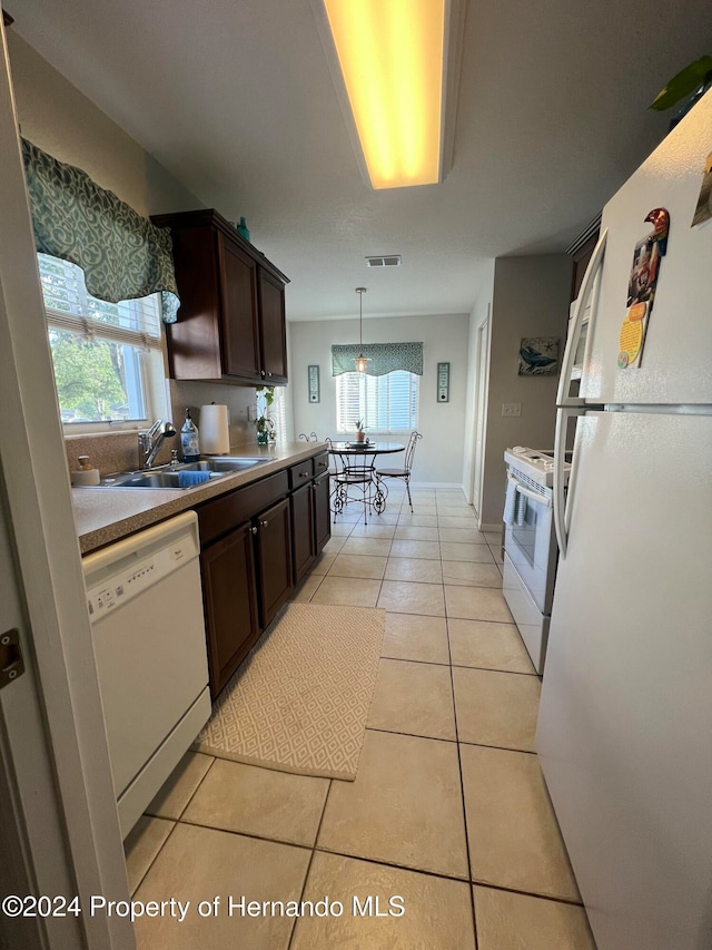 kitchen featuring dark brown cabinets, white appliances, sink, and light tile patterned floors