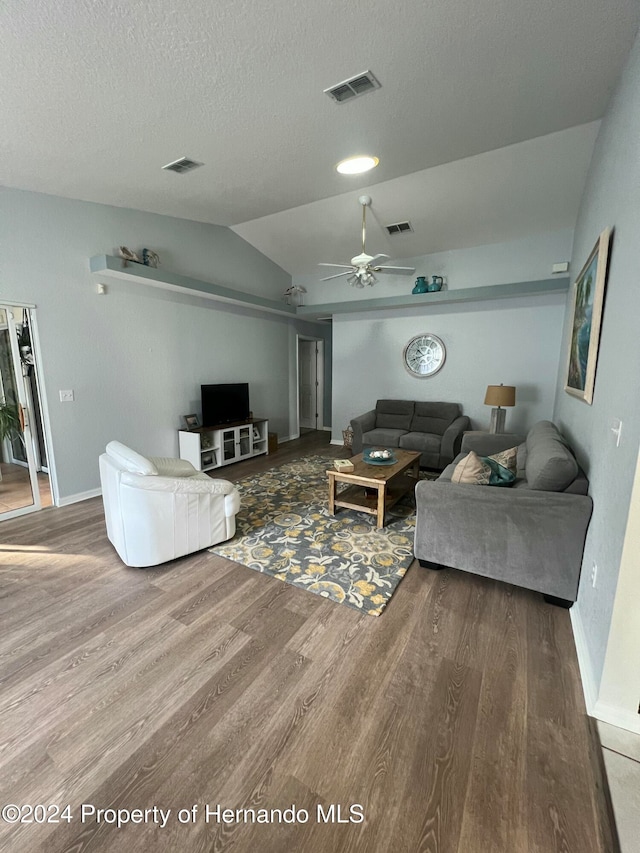 living room featuring wood-type flooring, ceiling fan, and vaulted ceiling