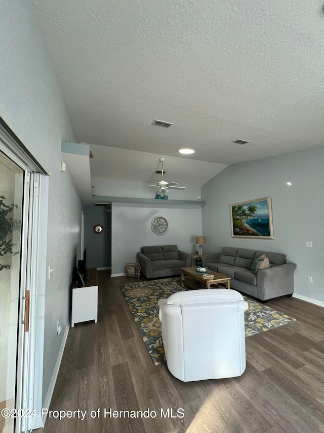 living room featuring a textured ceiling, dark hardwood / wood-style flooring, lofted ceiling, and ceiling fan