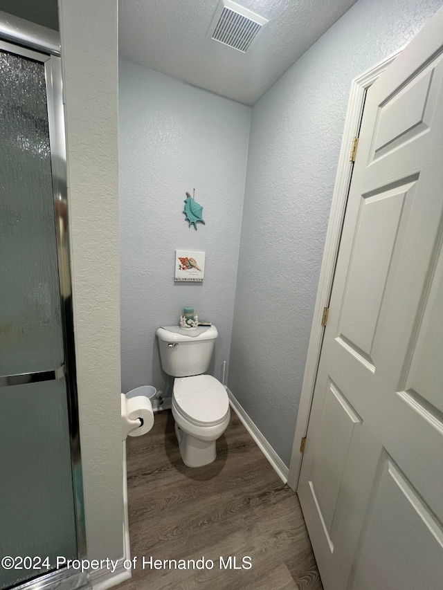 bathroom featuring toilet and wood-type flooring