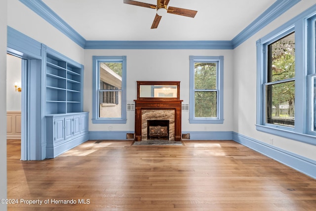 unfurnished living room featuring hardwood / wood-style flooring, crown molding, and a fireplace