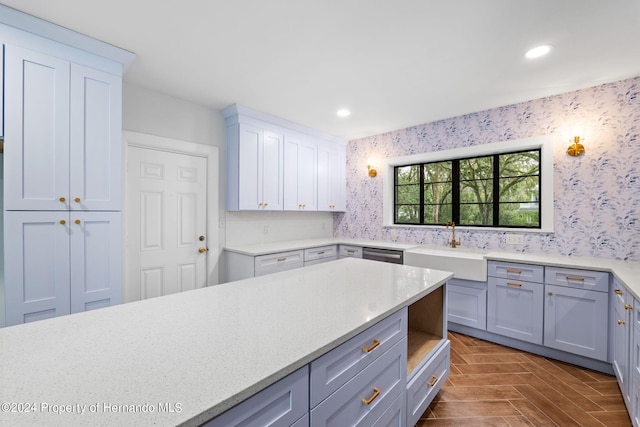 kitchen featuring stainless steel dishwasher, dark parquet flooring, gray cabinets, and sink