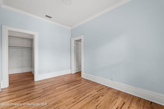 unfurnished bedroom featuring light hardwood / wood-style floors, a closet, and ornamental molding